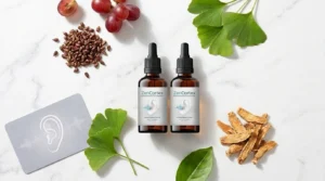Amber dropper bottle beside grapes ginkgo leaves and ginseng root on white marble — ZenCortex tinnitus hearing supplement honest review 2026
